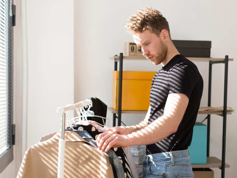 Homem organizando camisetas com TOC.