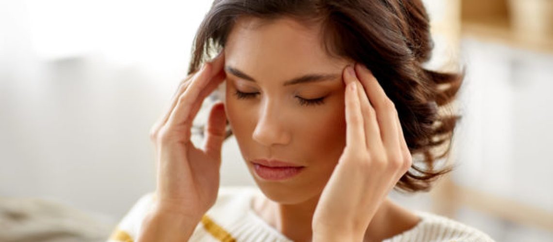 people , health and stress concept - unhappy woman suffering from head ache at home