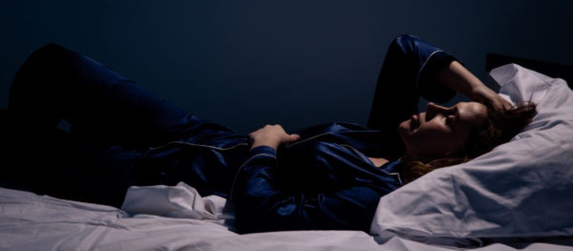 Sad alone woman lying the bed. Insomnia concept