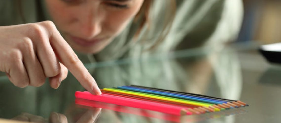Obsessive compulsive woman aligning up pencils accurately on a glass table